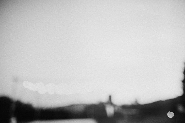 Blurred black and white landscape photo with a silhouette in the distance.