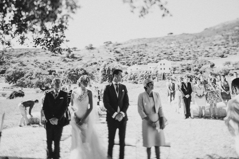 A black and white photograph of a wedding ceremony with guests gathered on a hillside.