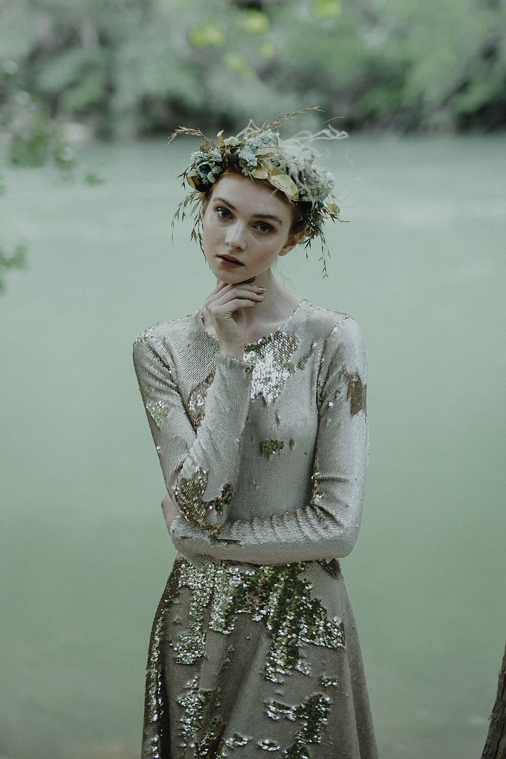 Ethereal portrait with delicate floral crown and embellished dress against a misty natural backdrop.