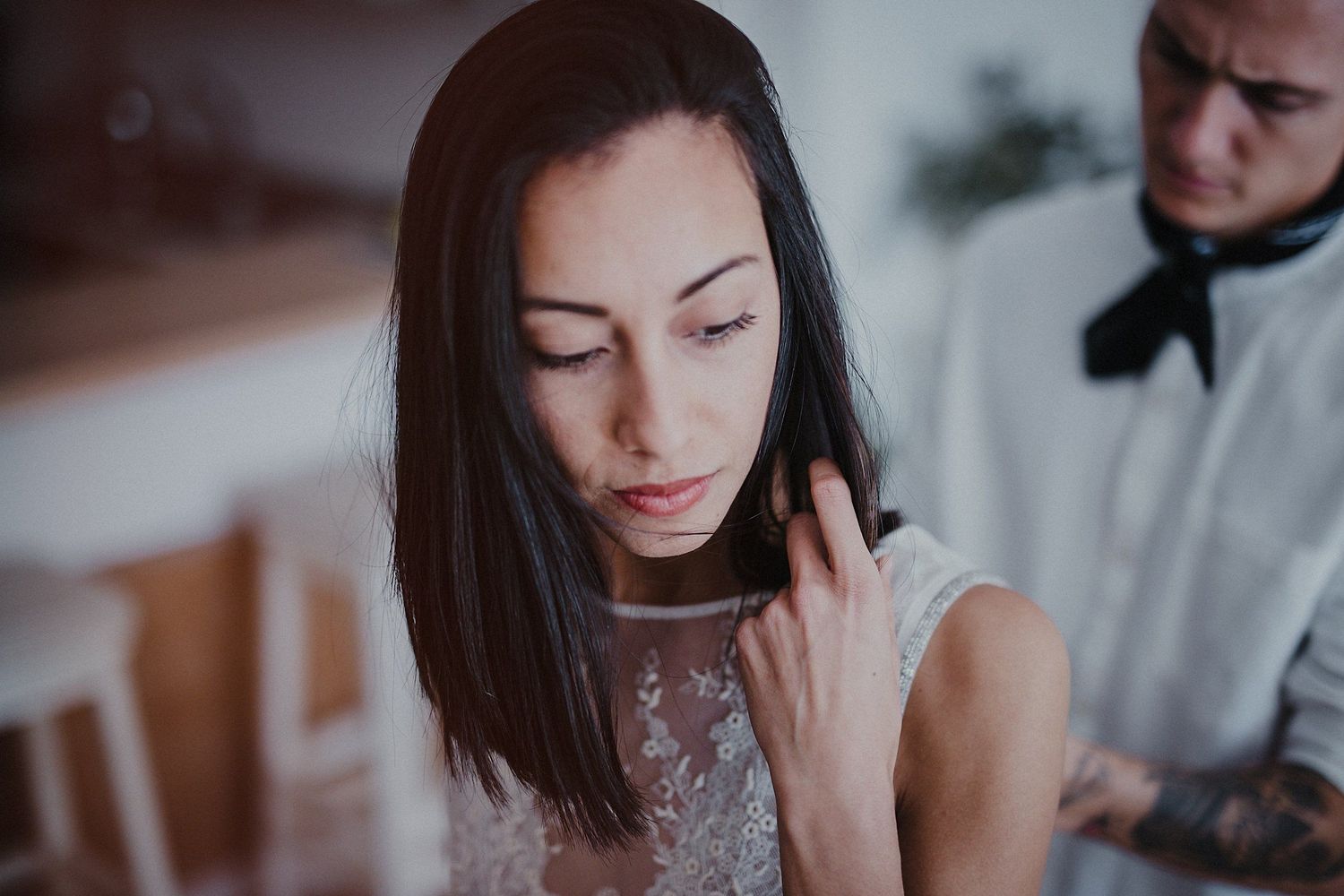 Soft-focused portrait in muted tones capturing a romantic moment indoors.