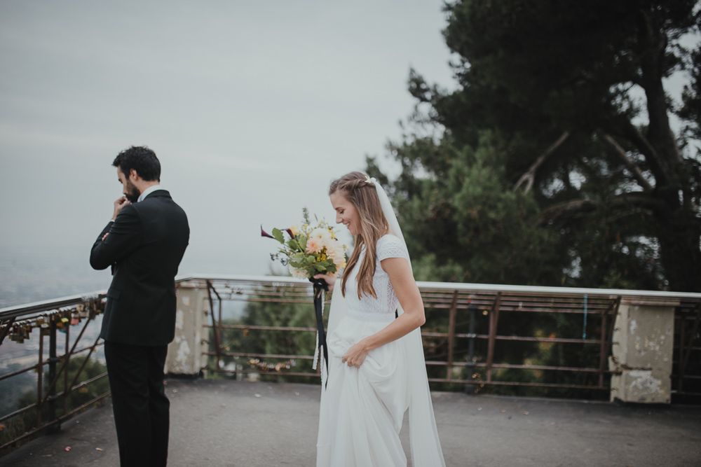 A wedding first look moment on a scenic overlook with cloudy skies.