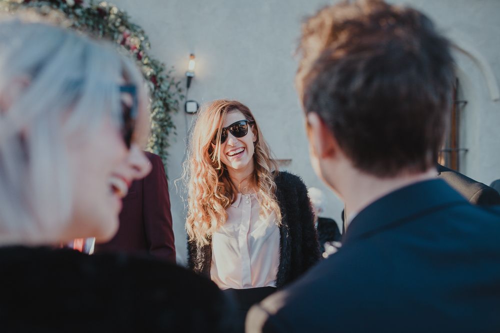 Wedding guests sharing laughs during an outdoor celebration.