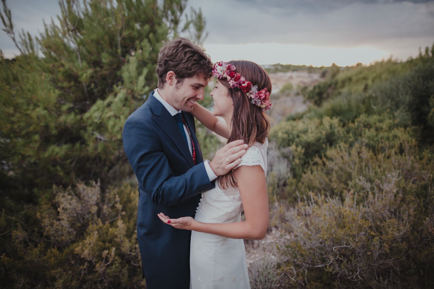 Intimate moment between couple in formal wear amongst natural landscape.