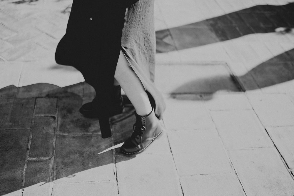 Black boots on wooden floorboards captured in dramatic black and white.