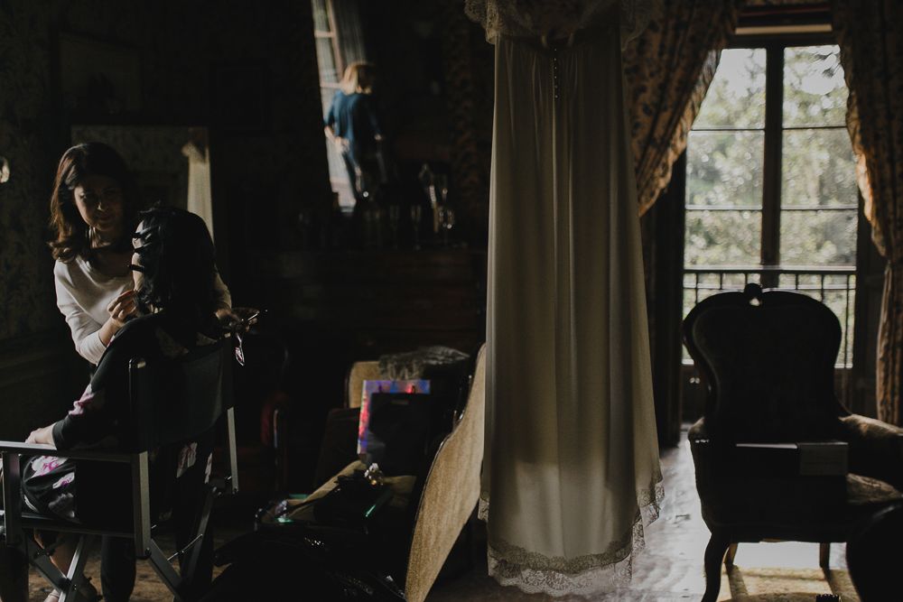 Dark moody interior scene with vintage furniture and flowing curtains.