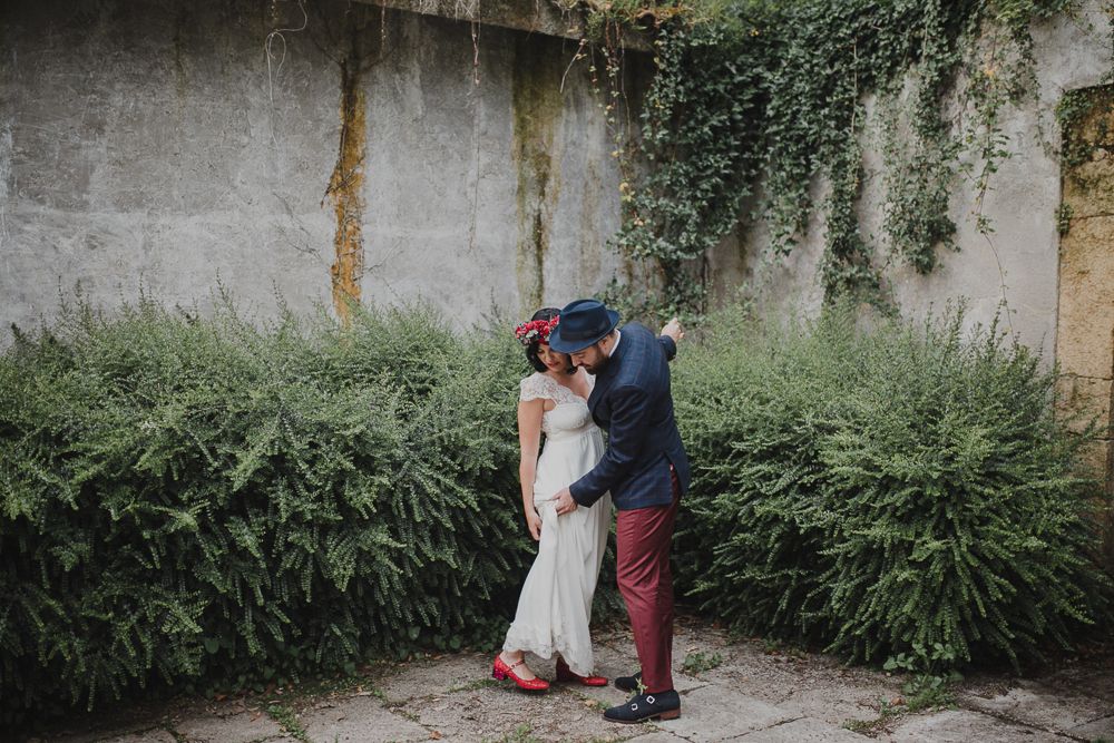 Romantic dance moment in courtyard with stone walls and lush greenery.