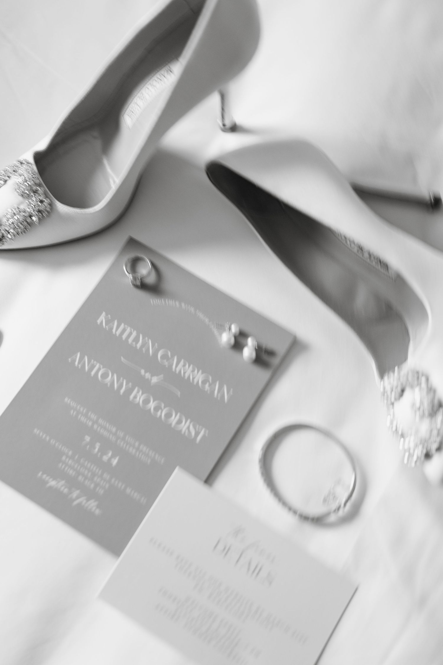 Wedding invitation suite with sparkly heels and jewelry in elegant gray tones.