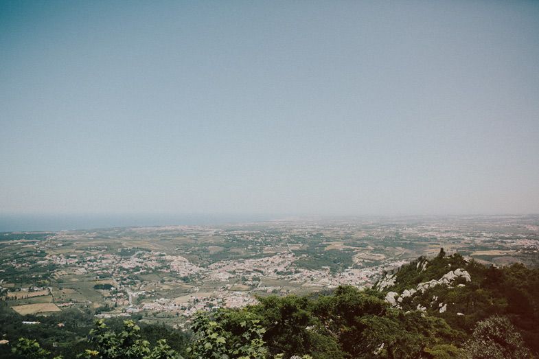 Aerial view of a sprawling city landscape from a mountain viewpoint on a hazy day.