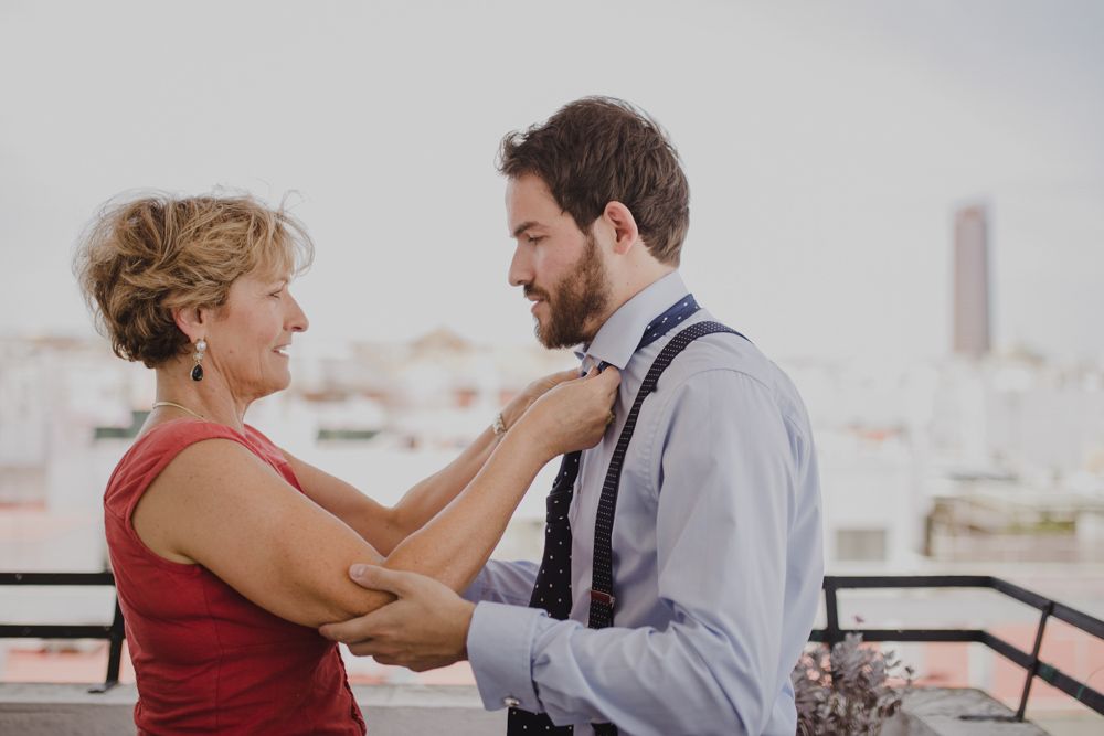 Tender moment shared on a rooftop with city buildings in background.