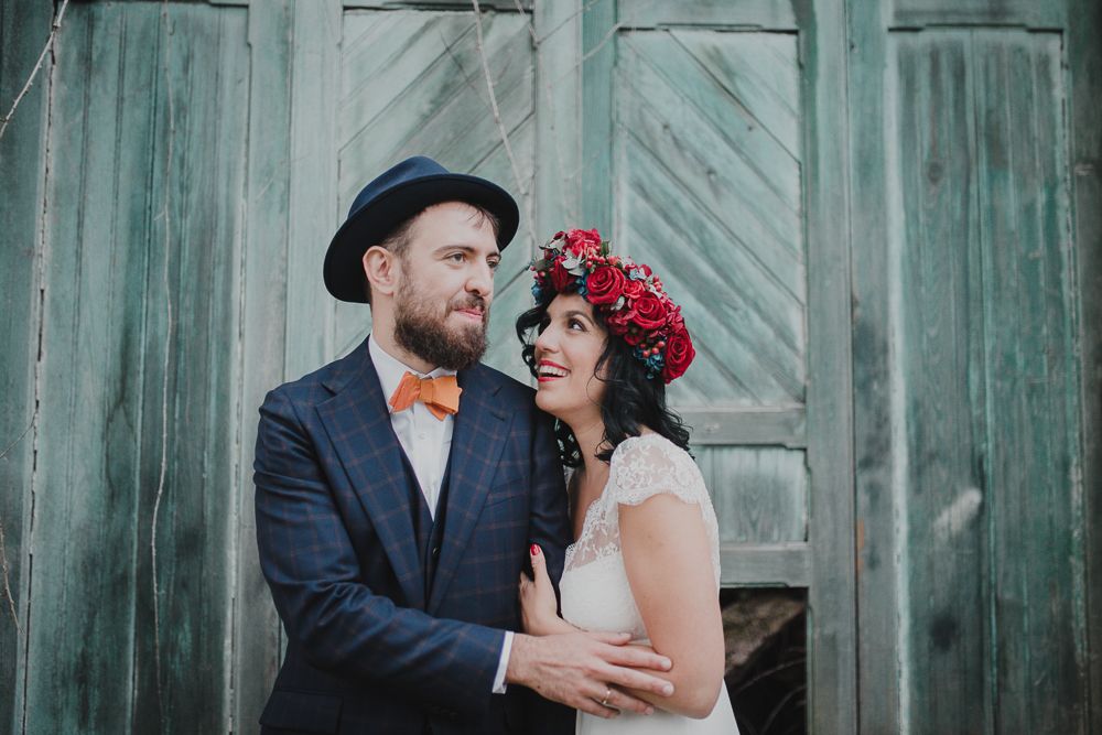 Wedding couple shares tender moment in front of antique turquoise doorway.