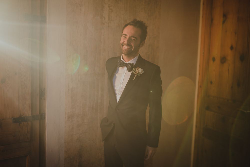 Dramatic portrait of a suited figure in formal wear with sunlight streaming through window.