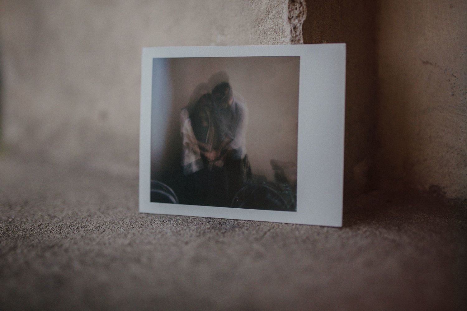 Polaroid photograph sitting on textured surface with soft lighting.