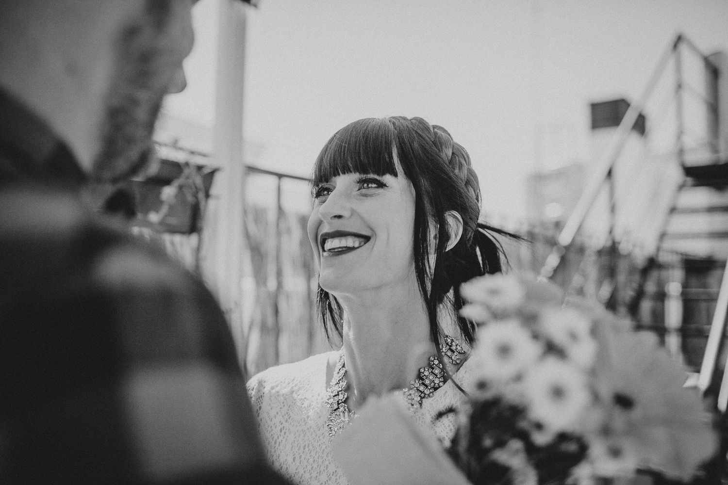 Black and white candid photo capturing laughter during outdoor moment.