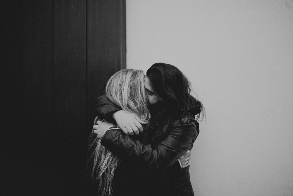 Close-up of an intimate romantic moment against brick wall.