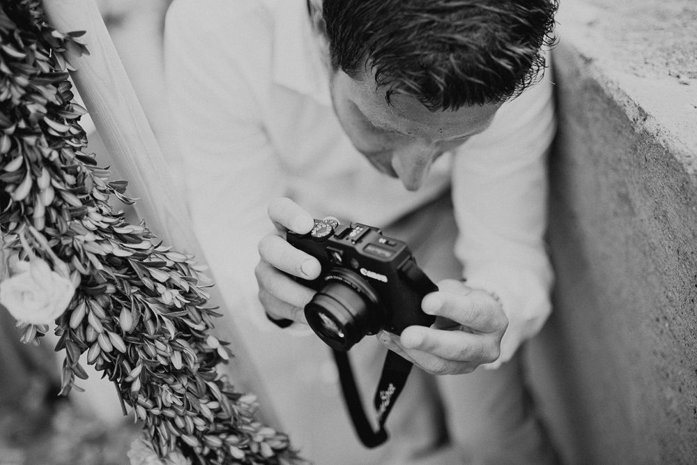 Black and white image of someone checking a camera during the wedding.
