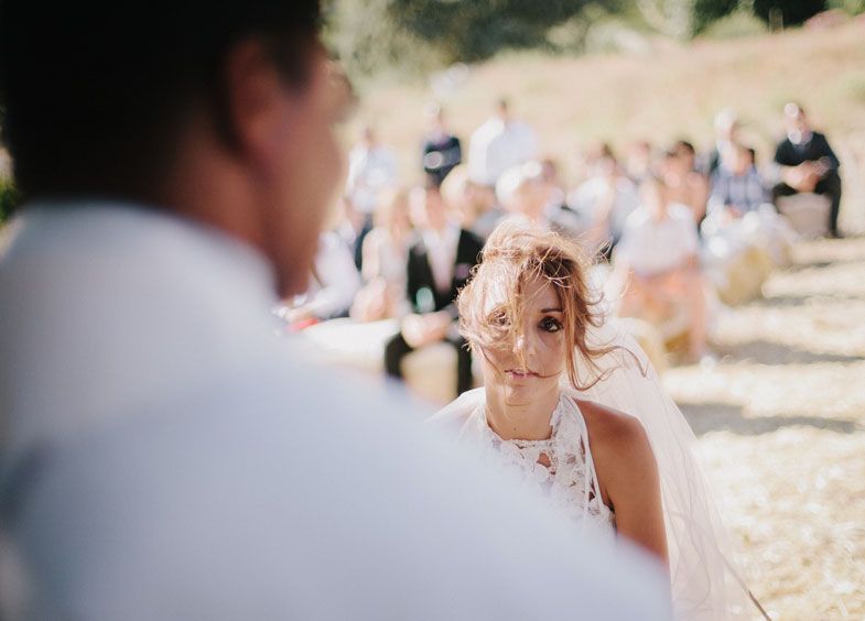 An intimate outdoor wedding ceremony moment captured in soft sunlight.