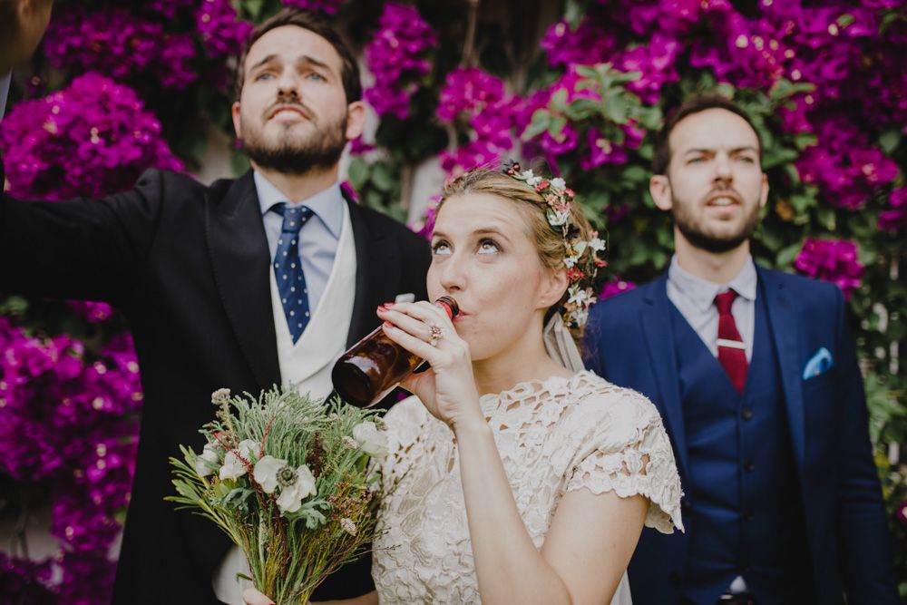 Wedding party poses against vibrant pink bougainvillea flowers.