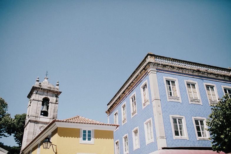 Blue and yellow buildings with traditional Portuguese architecture against a bright blue sky.