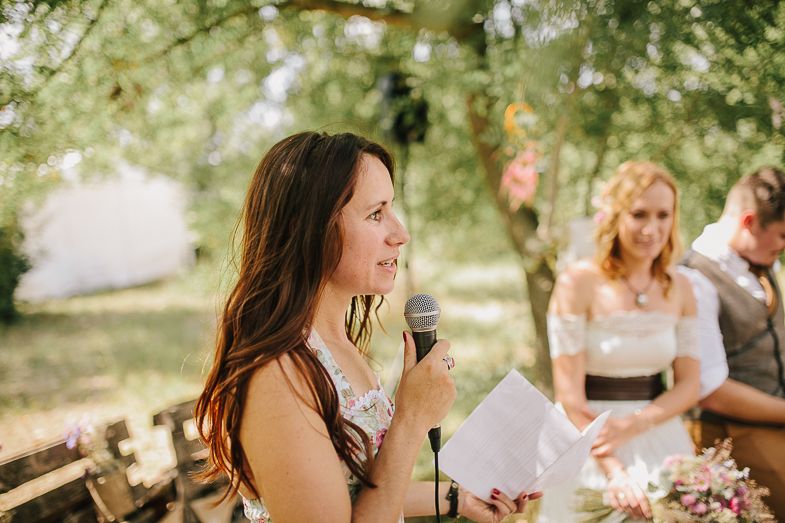 Guests share speeches and stories during an intimate outdoor wedding celebration.