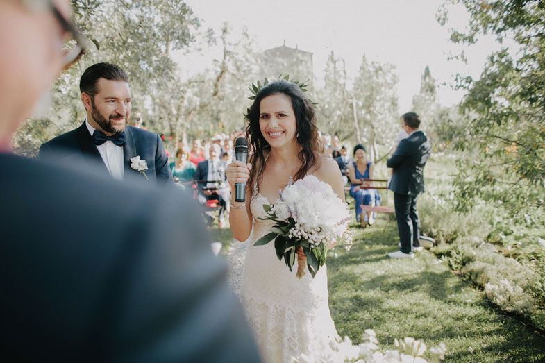 A touching moment during an outdoor wedding with a bride kneeling beside a young guest.