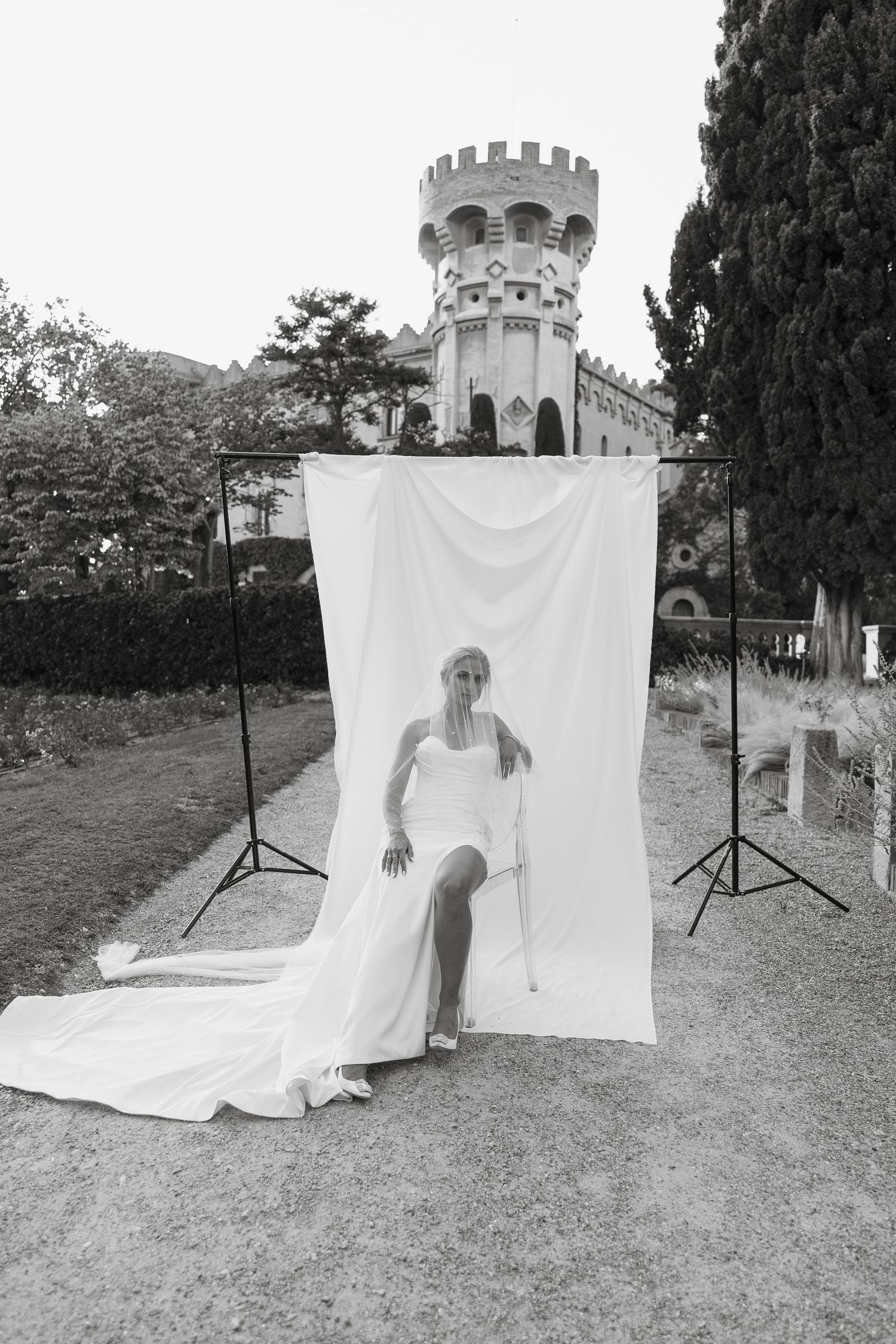Artistic black and white bridal portrait against white backdrop with castle tower.