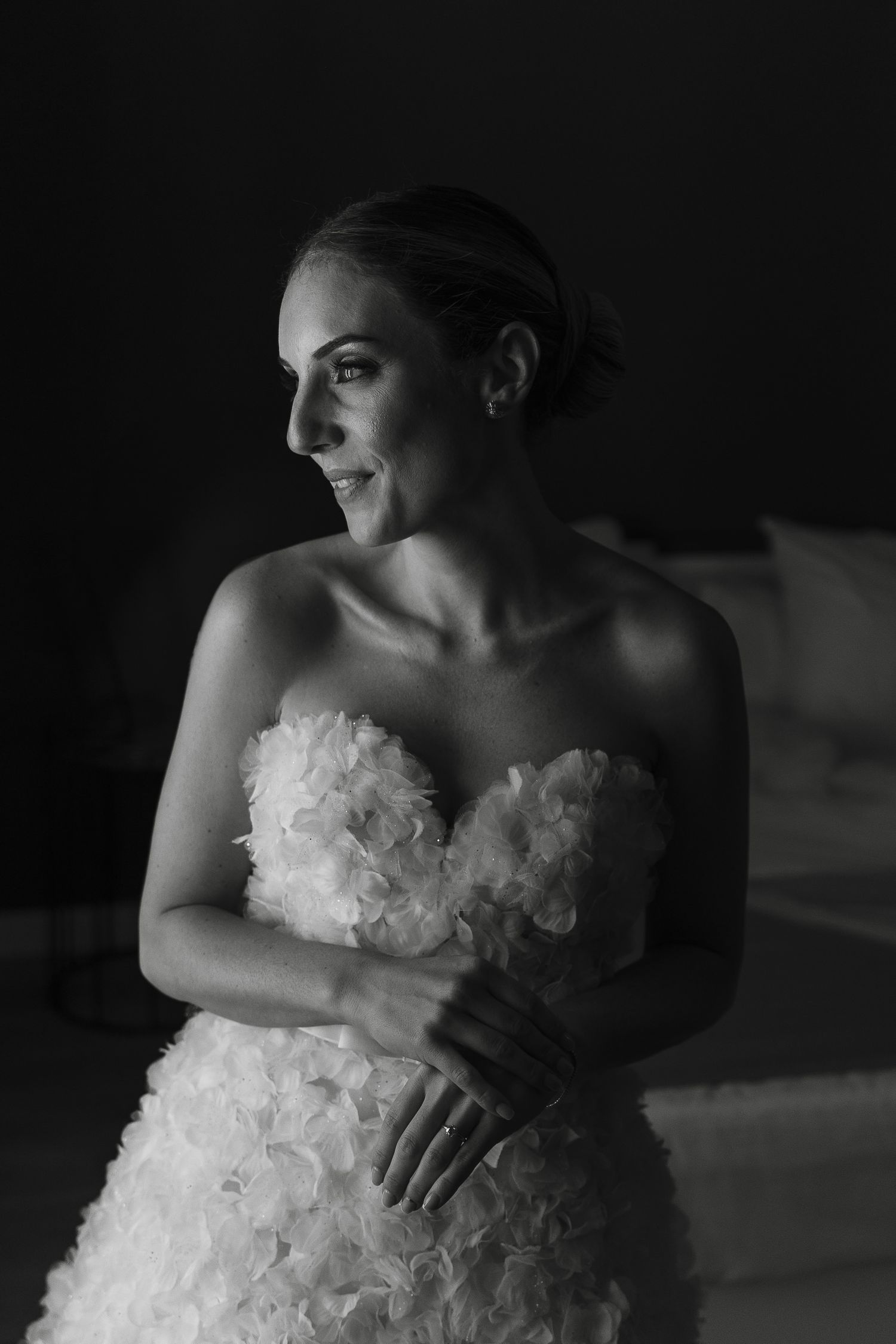 Black and white portrait of bride in strapless gown with natural lighting.