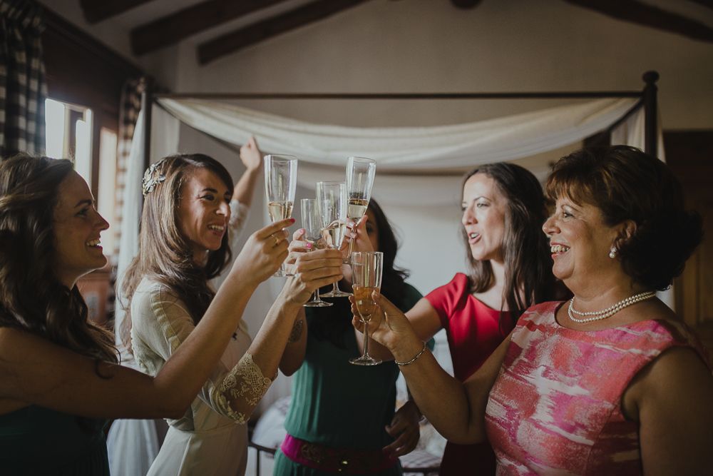 Candid shot of wedding guests raising glasses in a celebratory toast.