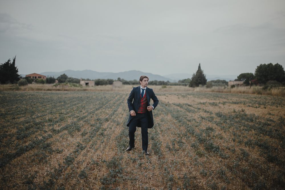 Person in suit standing confidently in center of rural field.