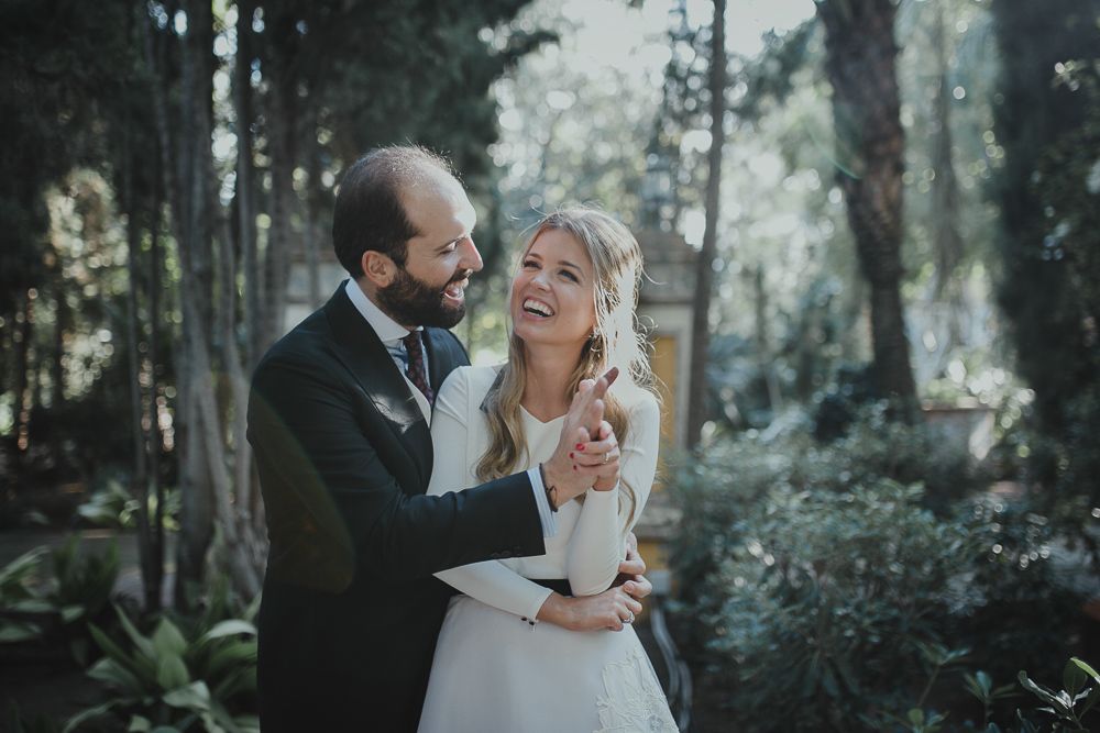 A joyful wedding moment captured in a forest setting with natural sunlight filtering through trees.