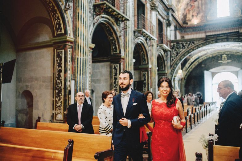 Wedding guests walk through the grand arches of a historic church during the ceremony.