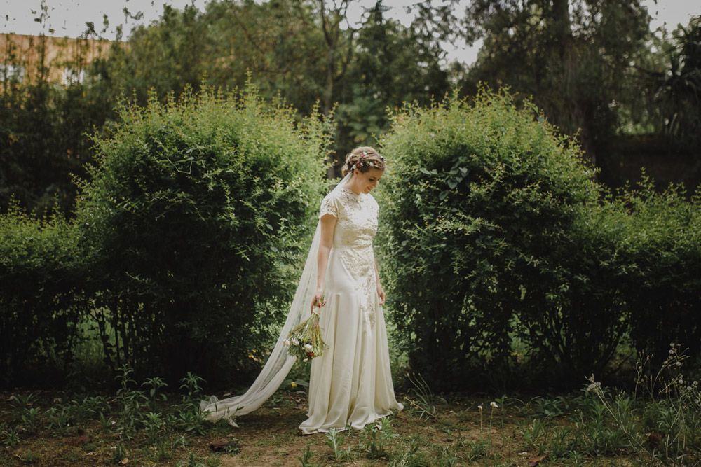 Ethereal bridal portrait in vintage-inspired gown against garden backdrop.