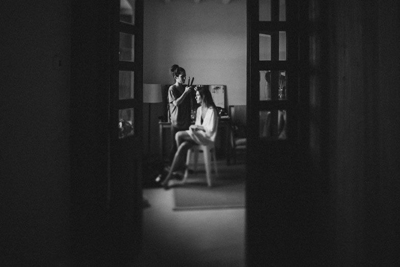A moody black and white indoor portrait through a doorframe.
