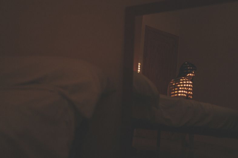 A dimly lit interior scene with a glowing decorative lantern in the background.