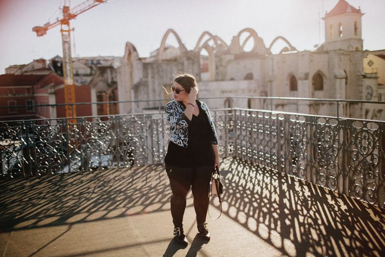 Tourist overlooking construction site with historic ruins and a crane in the background.