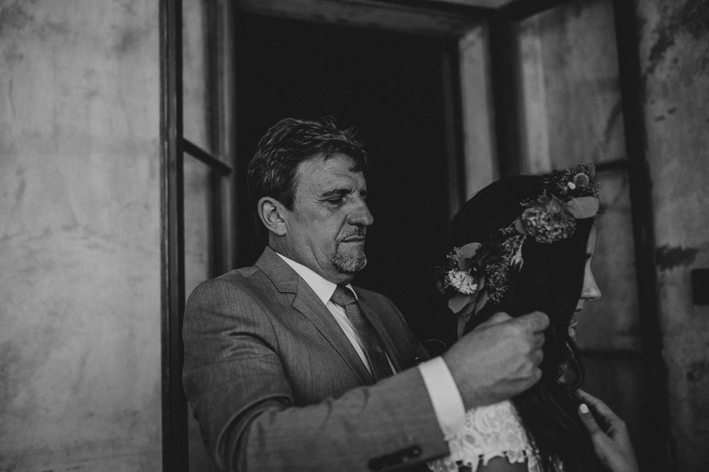 A vintage black and white photograph showing a person in a suit holding a camera.