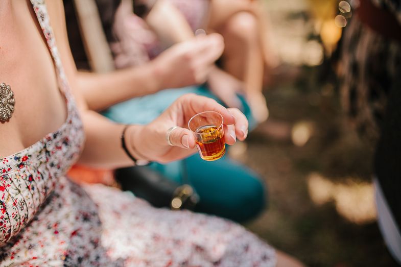 Hands holding small decorative items during an outdoor celebration.