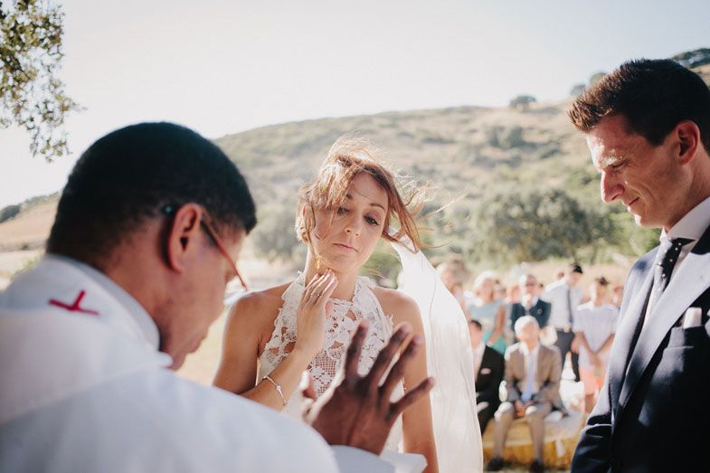 Intimate outdoor wedding ceremony moment captured during spiritual blessing or prayer.