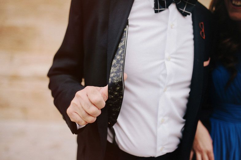 Close-up detail of formal attire showing a black suit jacket and white dress shirt.
