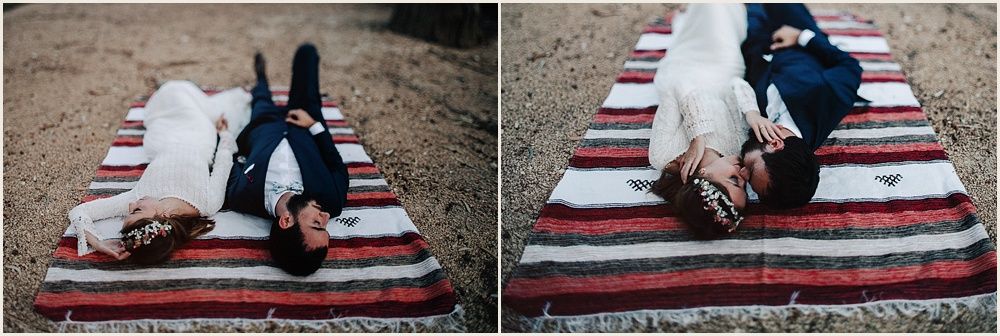 Couple relaxing on striped blanket in casual outdoor setting.
