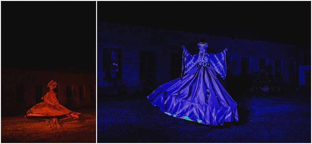 Dramatic red and blue lit figures in flowing dresses photographed at night.
