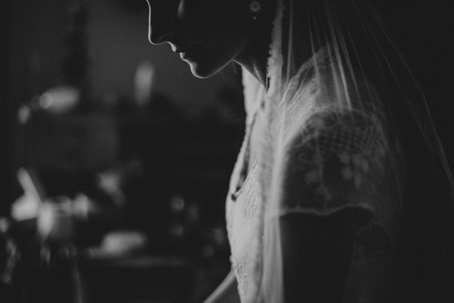 A moody black and white profile silhouette shows a person in soft lighting against a dark background.