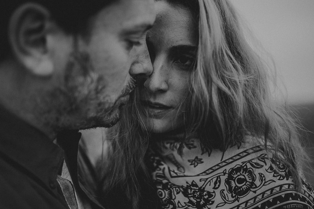 A close-up black and white portrait capturing an intimate moment between two people.