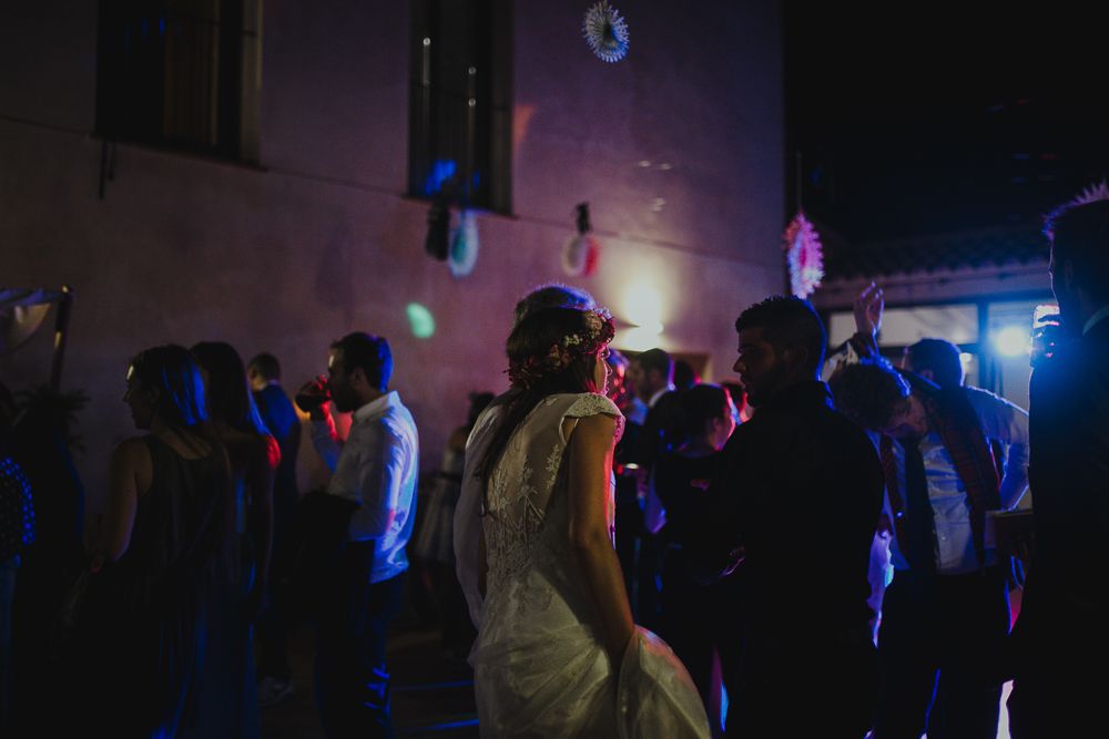 Dance party scene with disco lights and silhouetted guests at wedding reception.