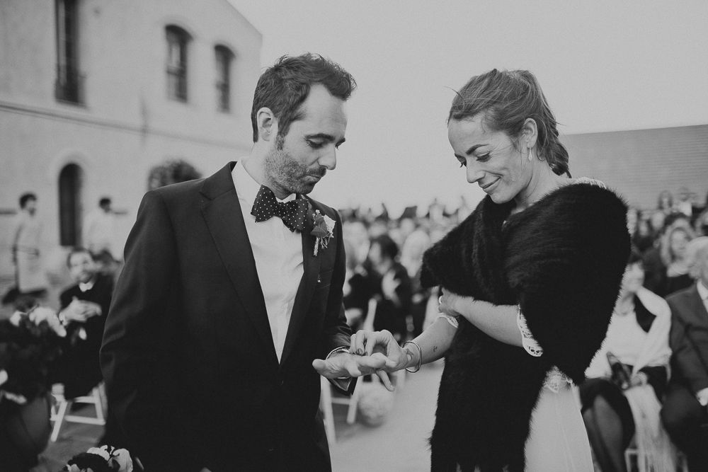 A black and white photo of a wedding ceremony showing two people during an intimate moment.