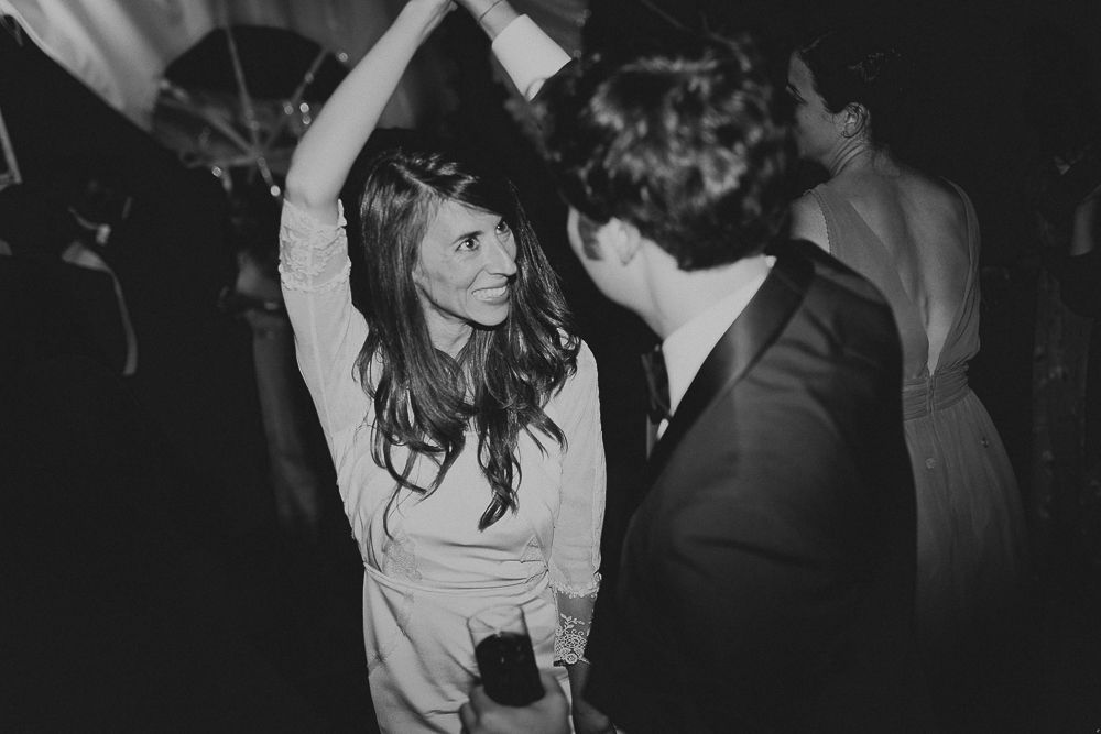 Black and white photo capturing joyful dance floor moments at a celebration.