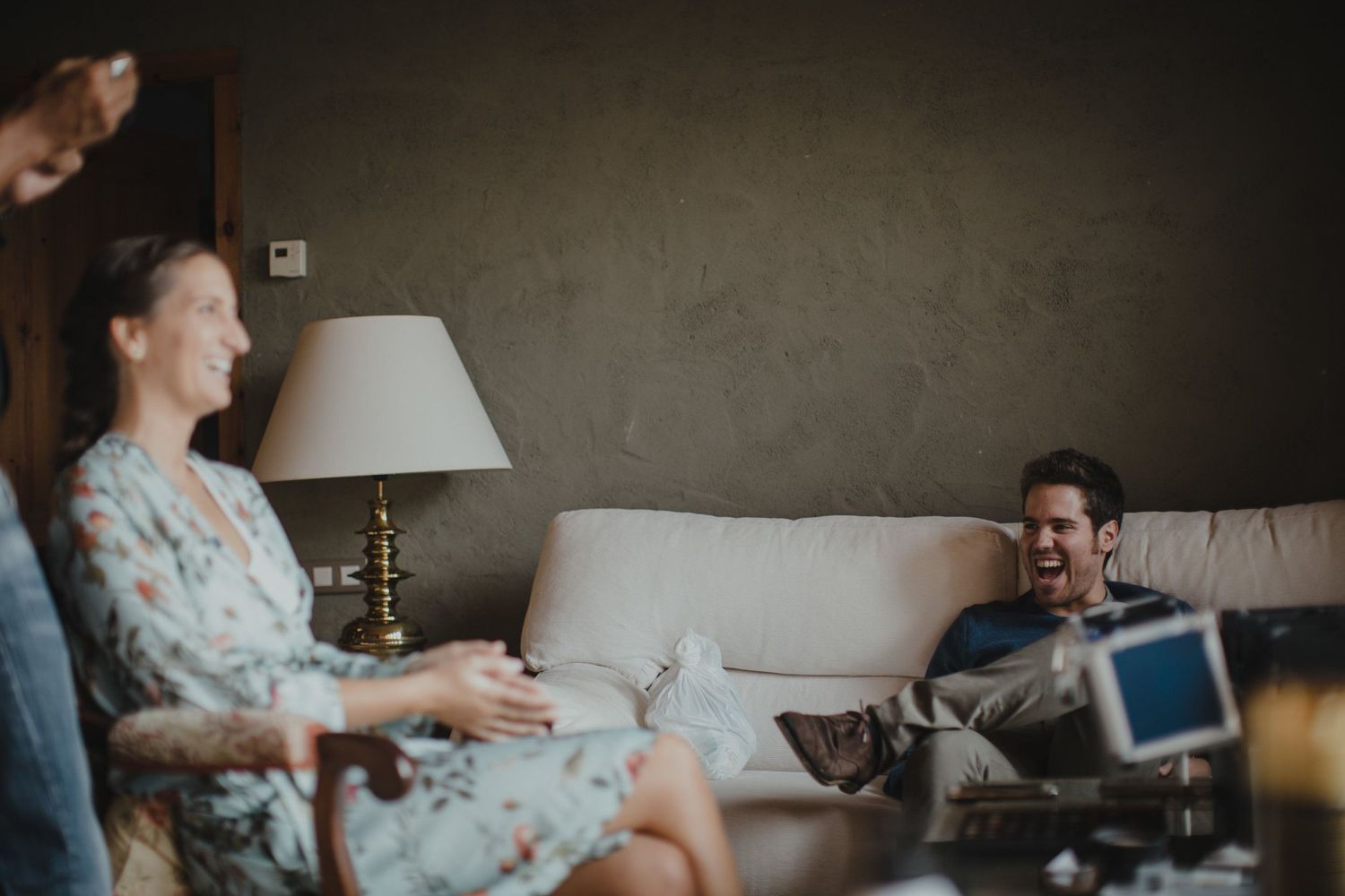 Candid moment in a living room with a table lamp and cozy sofa setting.