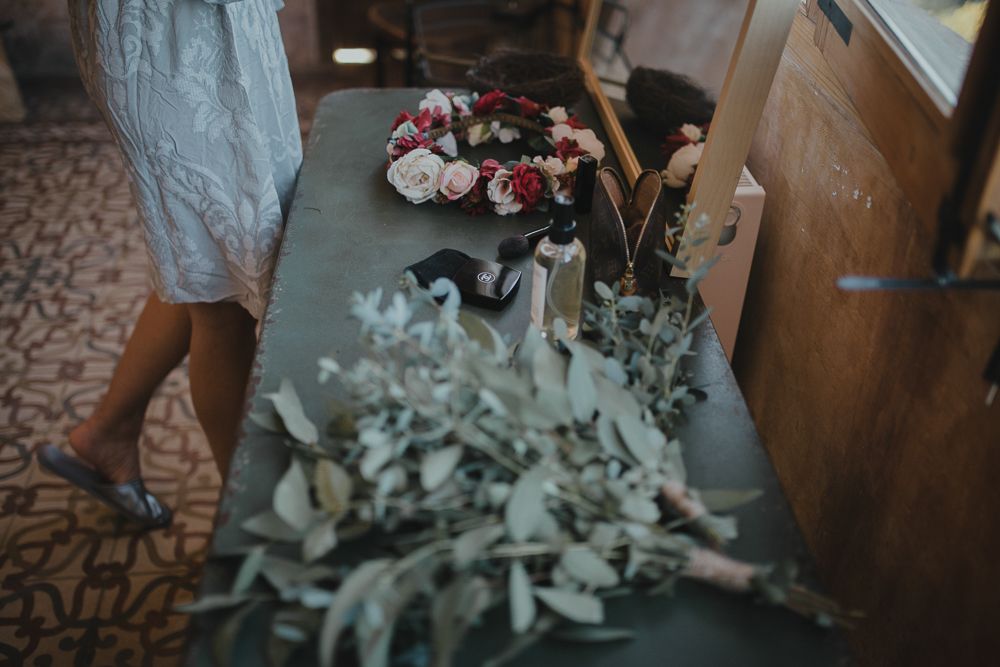 Wedding flowers and eucalyptus greenery arranged on a table with patterned tile floor.