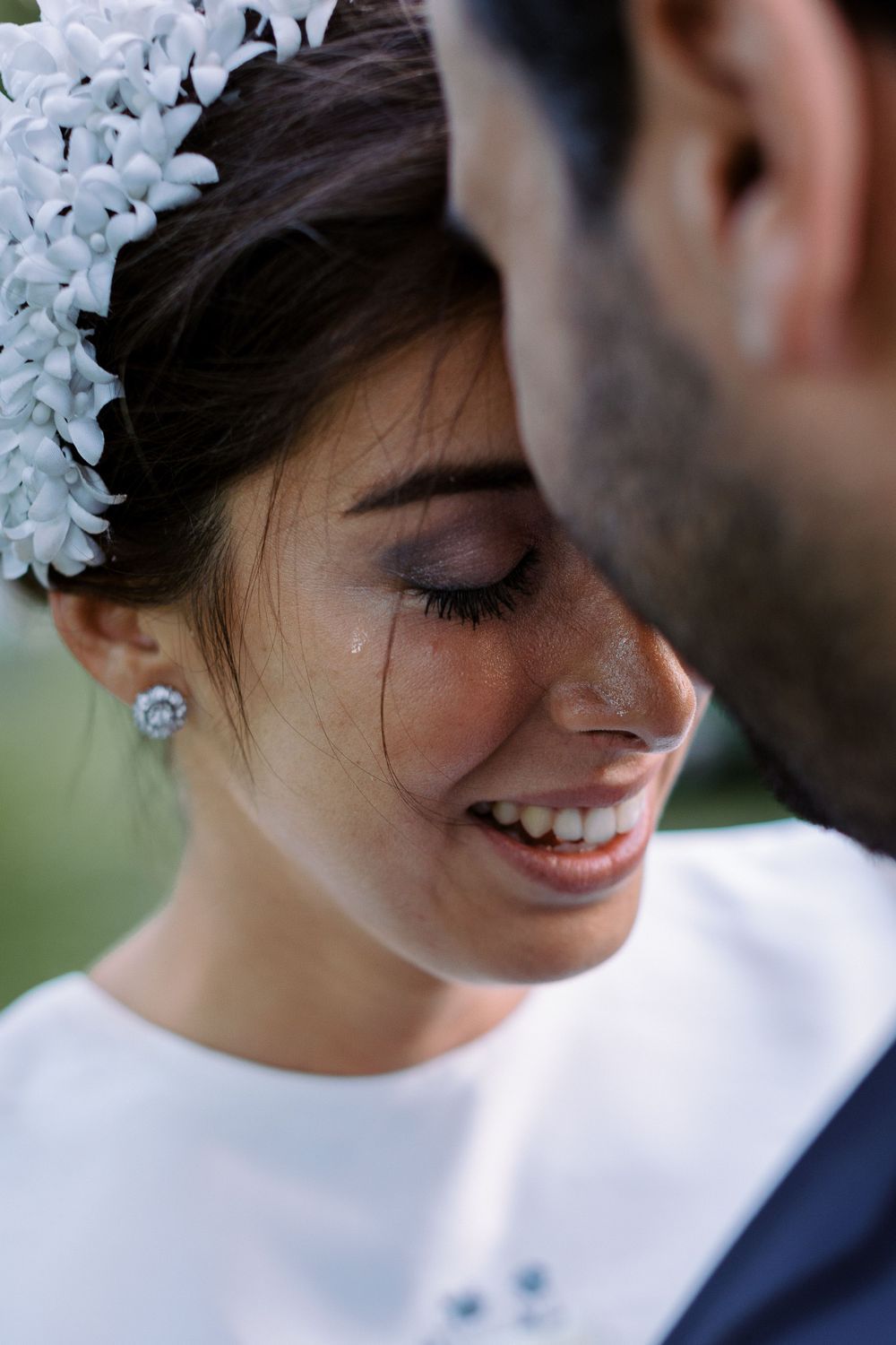Close-up detail of delicate white floral hair accessories against dark hair.