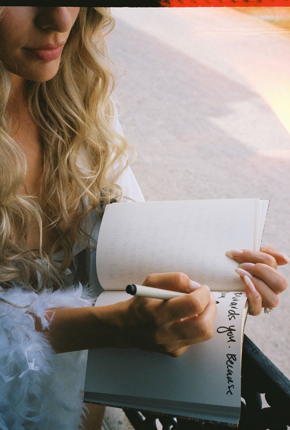 Hand holding a handwritten note with soft lighting and atmospheric smoke effect.