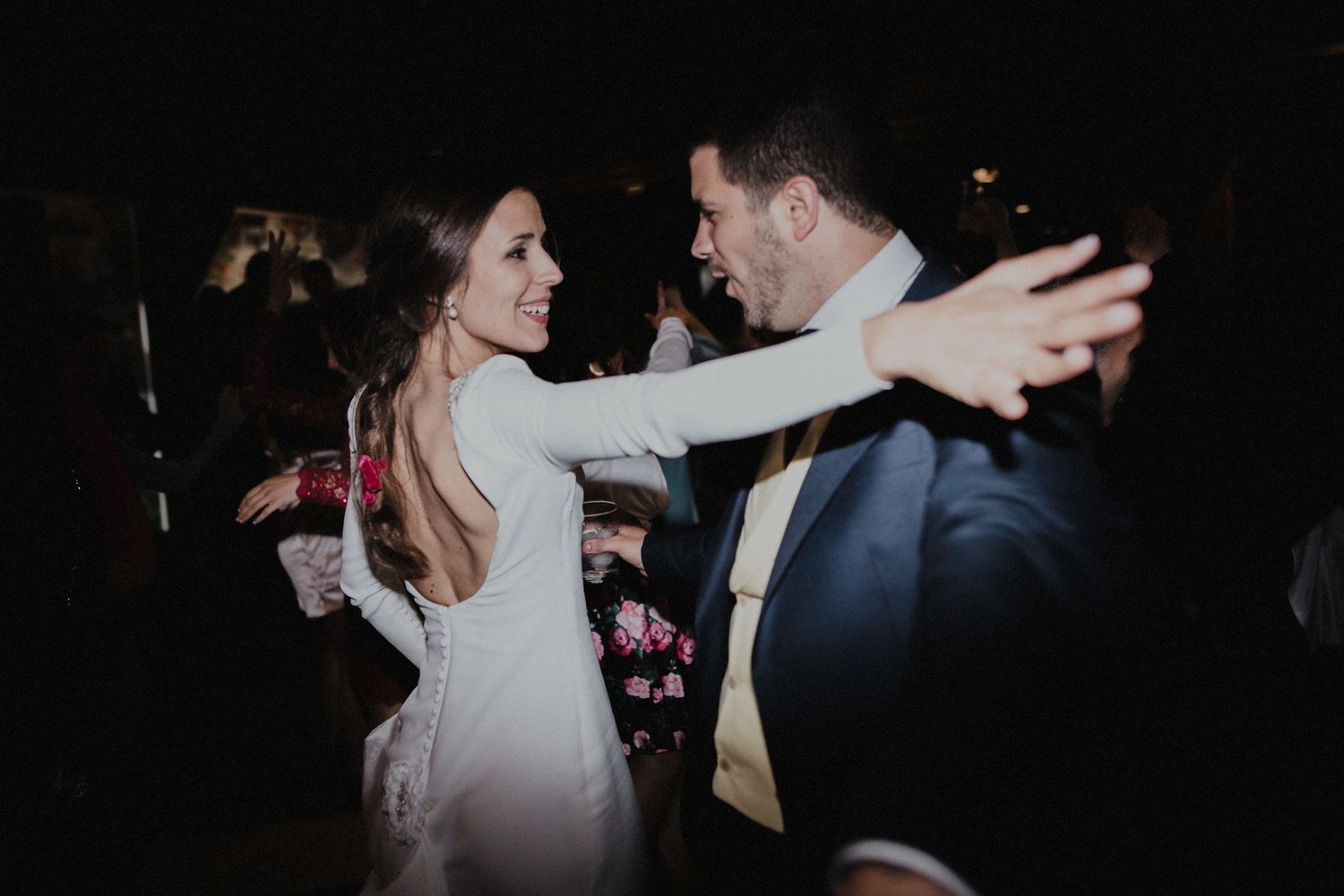 A couple dancing and laughing together at an evening celebration.